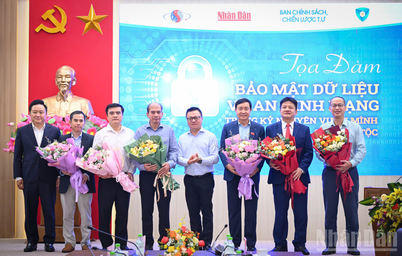 Đồng chí Lê Quốc Minh, Ủy viên Ban Chấp hành Trung ương Đảng, Tổng Biên tập Báo Nhân Dân, Phó trưởng Ban Tuyên giáo và Dân vận Trung ương, Chủ tịch Hội Nhà báo Việt Nam tặng hoa các diễn giả của buổi tọa đàm. Ảnh: THÀNH ĐẠT
