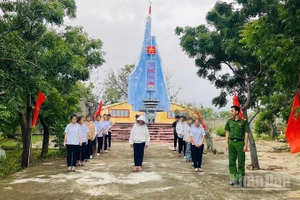 Thanh thiếu niên có hành vi vi phạm tập trung tại khuôn viên Đài tưởng niệm Liệt sĩ xã Phước Dinh để nghe Công an xã tuyên truyền, giáo dục pháp luật và tham gia lao động công ích có sự giám sát của công an xã. (Ảnh: NGUYỄN TRUNG)
