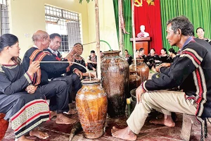  Người Mnông vui uống rượu cần trong lễ dạm ngõ.