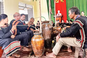  Người Mnông vui uống rượu cần trong lễ dạm ngõ.