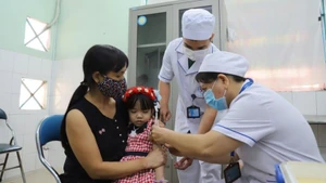 Phụ huynh đưa trẻ đến trạm y tế phường Tây Thạnh (Thành phố Hồ Chí Minh) tiêm chủng.