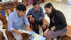 Nhân viên Bảo hiểm xã hội tỉnh Bình Phước tư vấn những lợi ích khi tham gia bảo hiểm xã hội tự nguyện cho người dân. (Ảnh: ĐỖ THOA)