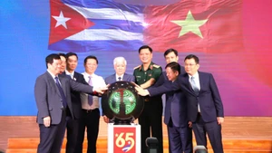 Các đại biểu thực hiện nghi thức phát động Chương trình vận động ủng hộ nhân dân Cuba với chủ đề “65 năm nghĩa tình Việt Nam-Cuba”.