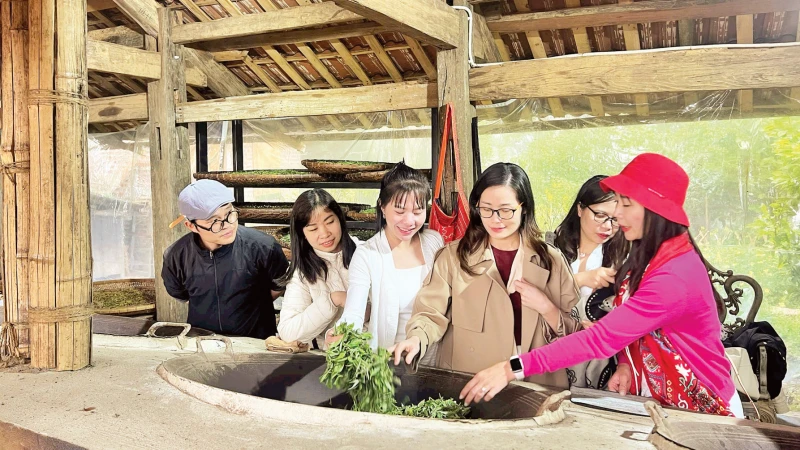 Du khách trải nghiệm sao trà bằng chảo gang.