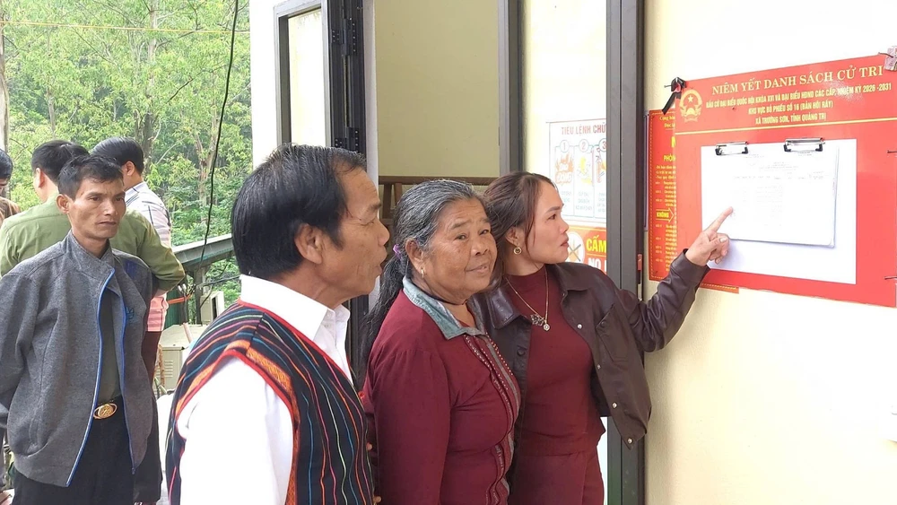 Cử tri bản Hôi Rấy, xã Trường Sơn (khu vực bỏ phiếu số 16) xem danh sách cử tri tại nhà văn hóa bản.