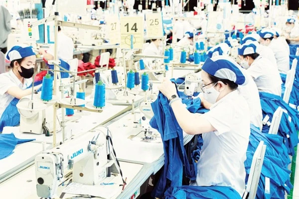 Công nhân làm việc tại một dây chuyền may mặc của Tổng Công ty cổ phần May Việt Tiến.