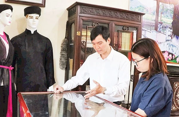 Liền anh Dương Đức Thắng giới thiệu các kỷ vật của người quan họ với du khách. 