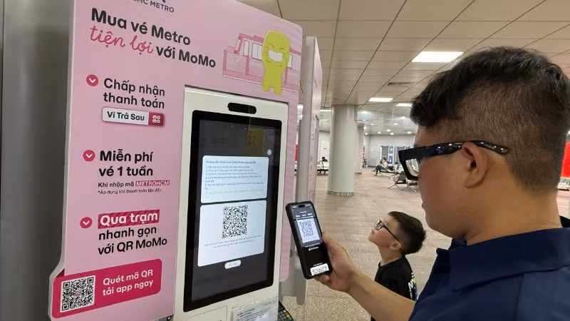 Hành khách thanh toán không dùng tiền mặt mua vé tàu để đi metro (Ảnh: QUÝ HIỀN)