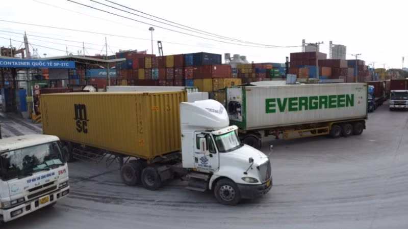 Xe container chở hàng hóa ra vào Cảng. (Ảnh: QUÝ HIỀN)