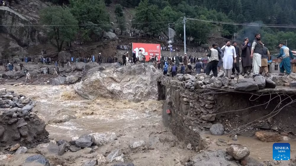 Người dân đứng trên nền những ngôi nhà bị lũ quét cuốn trôi tại tỉnh Nuristan, Afghanistan. (Ảnh: Tân Hoa xã)