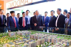 Ủy viên Bộ Chính trị, Phó Thủ tướng Thường trực Chính phủ Nguyễn Hòa Bình và đại biểu tham quan khu vực giới thiệu các dự án đầu tư tại Lâm Đồng.