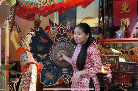 Chị Nguyễn Minh Nguyệt, thuyết minh cho khách tham quan về quá trình phục dựng lồng đèn xưa.