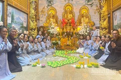 Cộng đồng người Việt Nam tại Lào thắp nến hoa đăng cầu nguyện cho đồng bào. (Ảnh: DUY TOÀN)