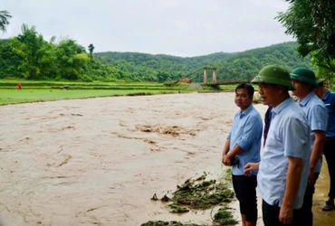Ông Nguyễn Thái Bình (phía trước, bên phải ảnh) kiểm tra tình hình mưa lũ tại địa bàn. (Ảnh Lan Lê)