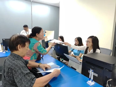 Điểm phục vụ hành chính công xã Thanh Trì (Hà Nội) hướng dẫn người dân làm thủ tục mua bán bất động sản. (Ảnh VĂN HỌC)