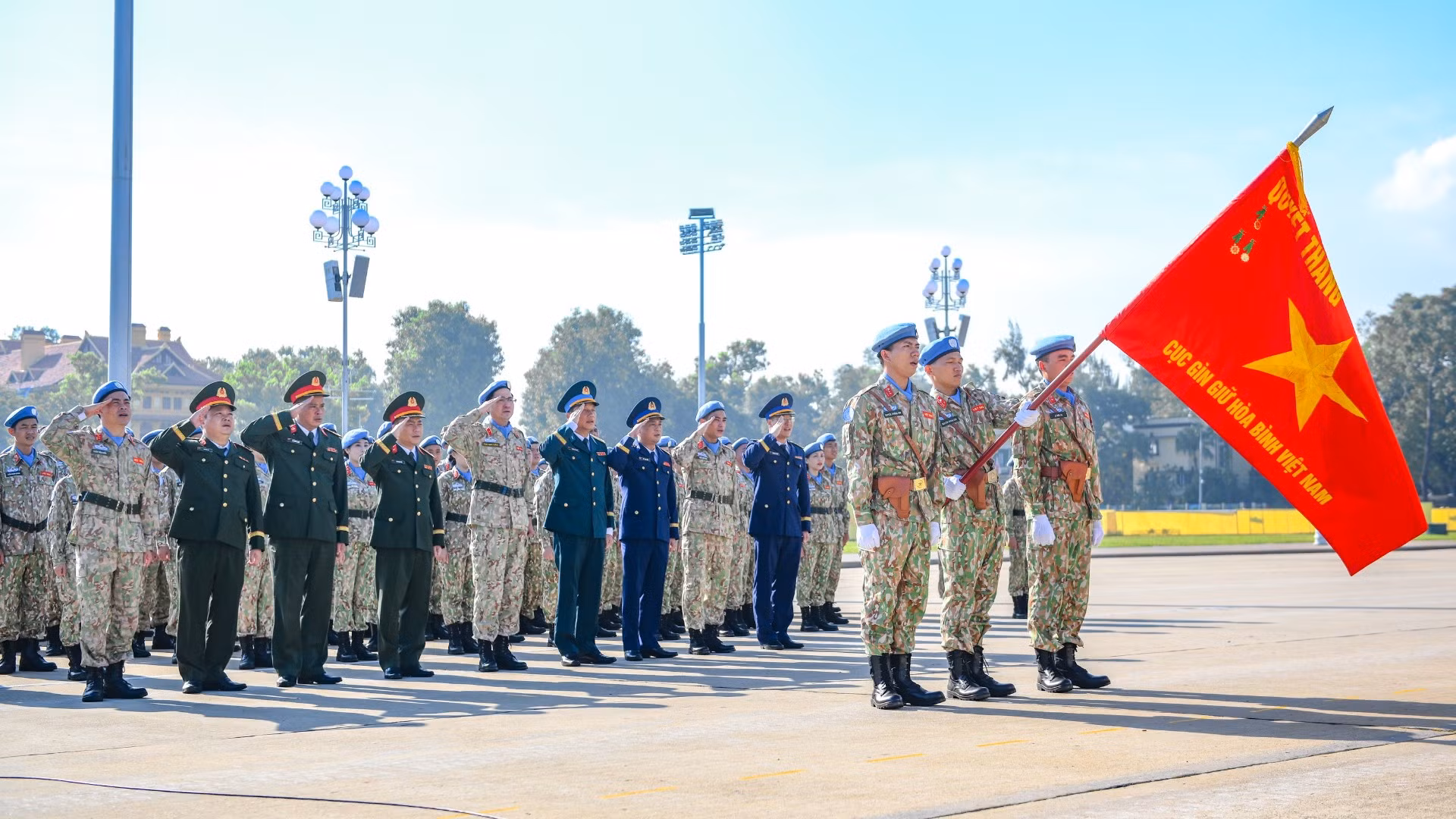Đại biểu, cán bộ và nhân viên Cục Gìn giữ hòa bình Việt Nam thực hiện nghi thức chào cờ.