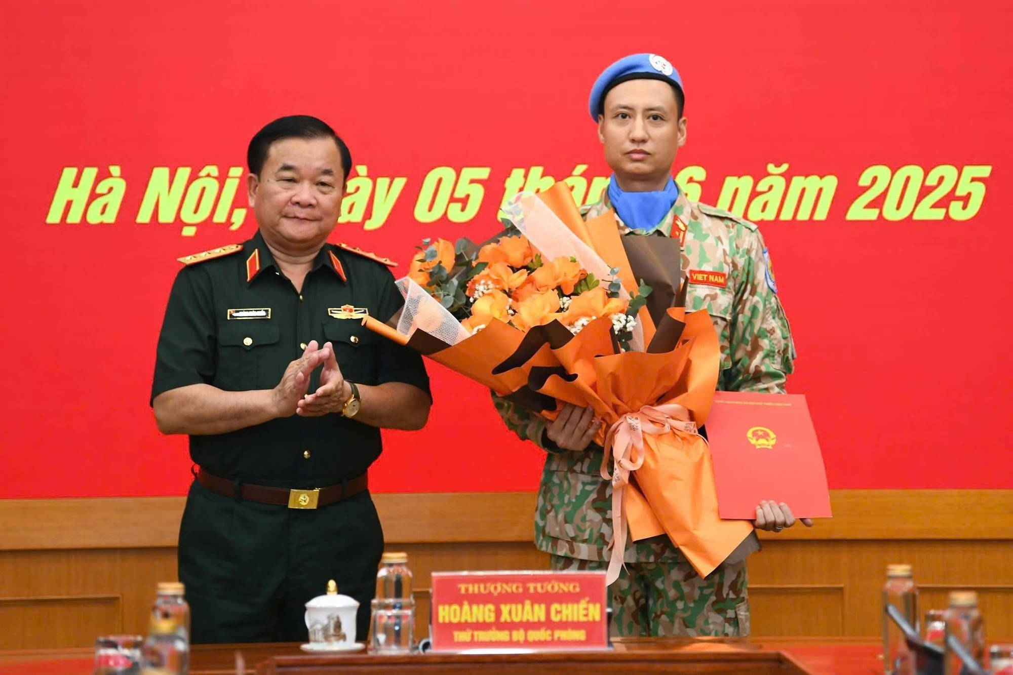 Thượng tướng Hoàng Xuân Chiến tặng hoa chúc mừng, động viên Thiếu tá Trần Viết Cường lên đường làm nhiệm vụ.