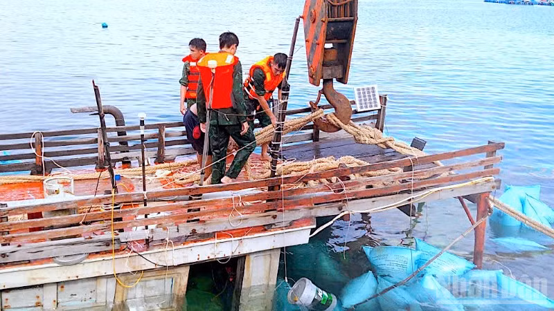 Cán bộ, chiến sĩ Đồn Biên phòng Hòn Chuối hỗ trợ trục vớt tàu cá gặp nạn trên vùng biển Cà Mau. 