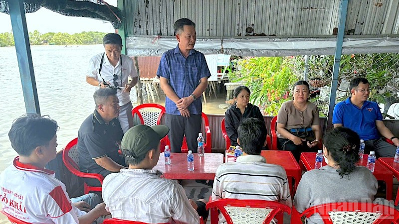 Phó Chủ tịch Ủy ban Mặt trận Tổ quốc Việt Nam tỉnh Cà Mau Nguyễn Văn Khởi (đứng, áo xanh) ân cần thăm hỏi các hộ dân có nhà bị cháy.