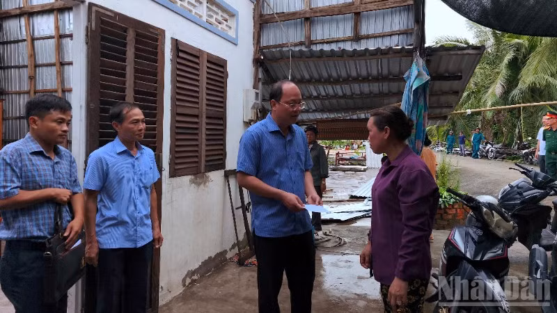 Bí thư Tỉnh ủy Cà Mau Nguyễn Hồ Hải (cầm phong bì) trao hỗ trợ cho hộ dân ấp Nhà Lầu 2 có nhà bị tốc mái.