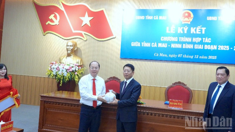 Bí thư Tỉnh ủy Cà Mau Nguyễn Hồ Hải (bìa trái) tặng quà lưu niệm cho đại diện tỉnh Ninh Bình tại lễ ký kết.