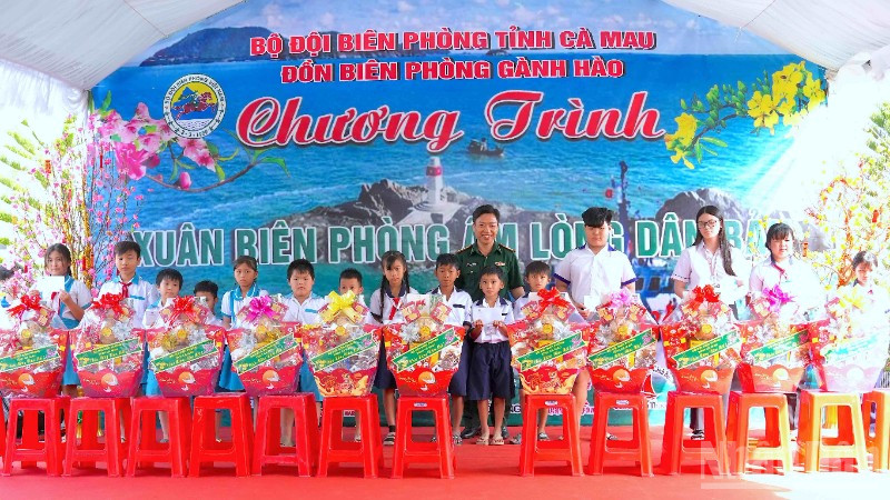 Đại tá Phạm Minh Giang, Chính ủy Bộ đội Biên phòng Cà Mau (đứng giữa) trao quà tặng học sinh nghèo vùng ven biển Gành Hào.