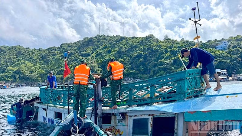 Cán bộ, chiến sĩ Đồn Biên phòng Hòn Chuối hỗ trợ trục vớt tàu cá gặp nạn bị chìm trên biển.