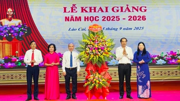 Bí thư Tỉnh ủy Trịnh Xuân Trường tặng hoa chúc mừng nhà trường. (Ảnh: THANH SƠN)