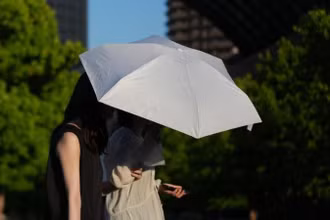 Người dân che ô đi bộ trên phố ở Tokyo, Nhật Bản, ngày 18/6/2025. (Ảnh minh họa: Xinhua)