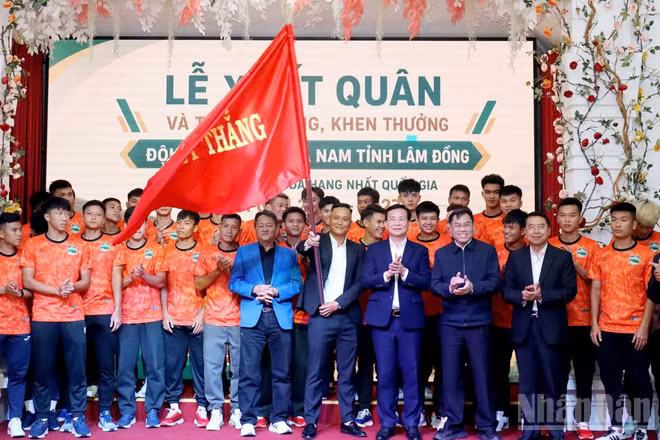 Lãnh đạo tỉnh Lâm Đồng thực hiện nghi thức trao cờ cho đội tuyển bóng đá nam tại Lễ xuất quân. (Ảnh: MAI VĂN BẢO)