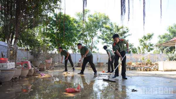 Đại úy Nguyễn Văn Kiên (ngoài cùng bên phải) cùng đồng đội hỗ trợ khắc phục hậu quả bão lũ tại chùa An Lạc.
