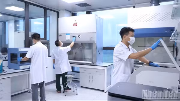 Kỹ thuật viên thực hiện các bước trong quy trình giám định ADN mẫu hài cốt liệt sĩ. (Ảnh: THANH TÚ)