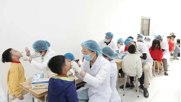 Các bác sĩ thăm khám sức khỏe răng miệng cho học sinh.