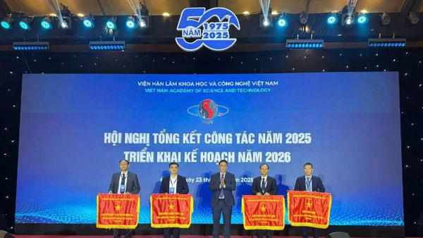Giáo sư, Viện sĩ Châu Văn Minh, Chủ tịch Viện Hàn lâm Khoa học và Công nghệ Việt Nam, trao Cờ thi đua cho các đơn vị. (Ảnh: BÍCH LIÊN)