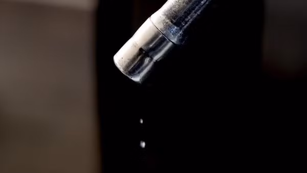 Xăng nhỏ giọt từ vòi bơm tại trạm xăng ở London, Anh. (Ảnh: THX/TTXVN)