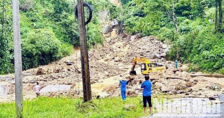 Chính quyền địa phương phối hợp với các ngành chức năng huy động máy móc để san gạt đất đá tràn xuống mặt đường. a12-2216.jpg