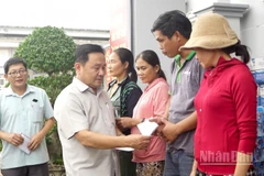 Phó Chủ tịch Hội đồng nhân dân thành phố Đà Nẵng Nguyễn Công Thanh tặng quà cho các hộ dân ở xã Quế Phước bị thiệt hại nặng do mưa lũ gây ra.