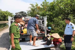 Lực lượng chức năng tỉnh Quảng Nam thu gom các sản phẩm nước mắm bị vứt bỏ để phục vụ công tác điều tra.