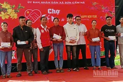 Lãnh đạo xã Sơn Cẩm Hà trao quà cho người dân.