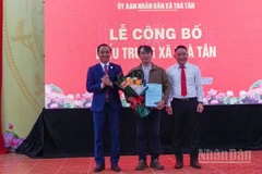 Lãnh đạo xã Trà Tân tặng hoa cho tác giả thiết kế biểu trưng xã Trà Tân.