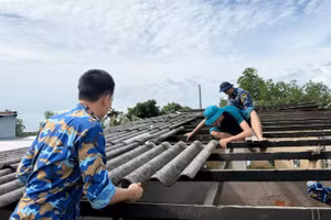 Cán bộ, chiến sĩ Lữ đoàn 175 cùng các lực lượng tháo dỡ phần mái nhà bị hư hỏng do dông lốc. (Ảnh: Vùng 5 Hải quân cung cấp)