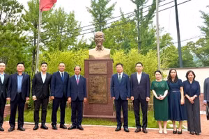 Đoàn công tác chụp ảnh cùng Đại sứ Vũ Hồ và cán bộ Đại sứ quán bên Tượng đài Chủ tịch Hồ Chí Minh trong khuôn viên Đại sứ quán. 