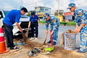 Cán bộ, chiến sĩ Vùng 5 Hải quân và đoàn viên thanh niên địa phương vệ sinh đường giao thông. 