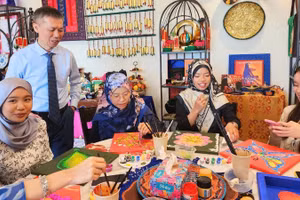 Tiến sĩ Trần Trọng Nghĩa và sinh viên Đại học Quốc gia Brunei trải nghiệm hoạt động trang trí họa tiết truyền thống của Việt Nam và Brunei Darussalam. (Ảnh do Đại sứ quán Việt Nam tại Brunei cung cấp)