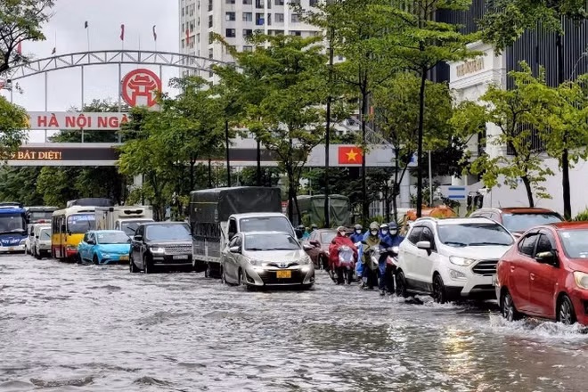 Ngập sâu tại Quốc lộ 32 khiến việc di chuyển của người dân gặp nhiều khó khăn. (Ảnh: VĂN THỊNH)