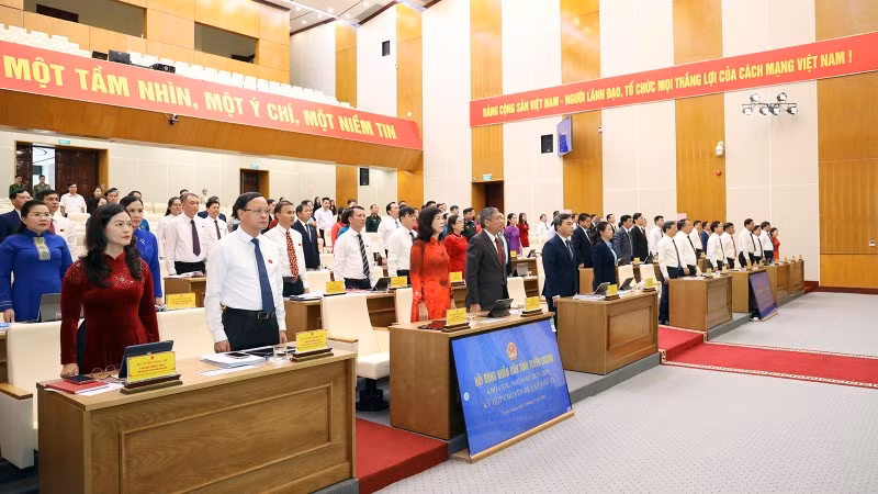 Đại biểu dự kỳ họp thực hiện nghi thức chào cờ.