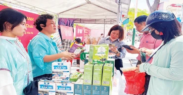 Người dân mua sắm tại các gian hàng trong hội chợ. (Ảnh XUÂN TRƯỜNG)