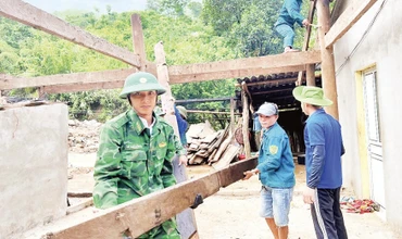 Cán bộ, chiến sĩ Đồn Biên phòng Nhôn Mai phối hợp các lực lượng di dời nhà dân bị ảnh hưởng do lũ quét.