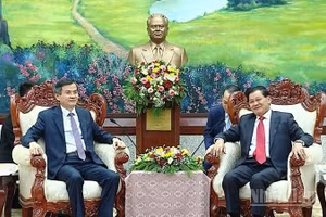 Đồng chí Đoàn Minh Huấn (bìa trái) chào xã giao Tổng Bí thư, Chủ tịch nước Lào Thongloun Sisoulith. (Ảnh: DUY TOÀN)