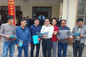 Cán bộ Hải đội 137 tuyên truyền chống khai thác hải sản bất hợp pháp, không báo cáo và không theo quy định cho ngư dân.